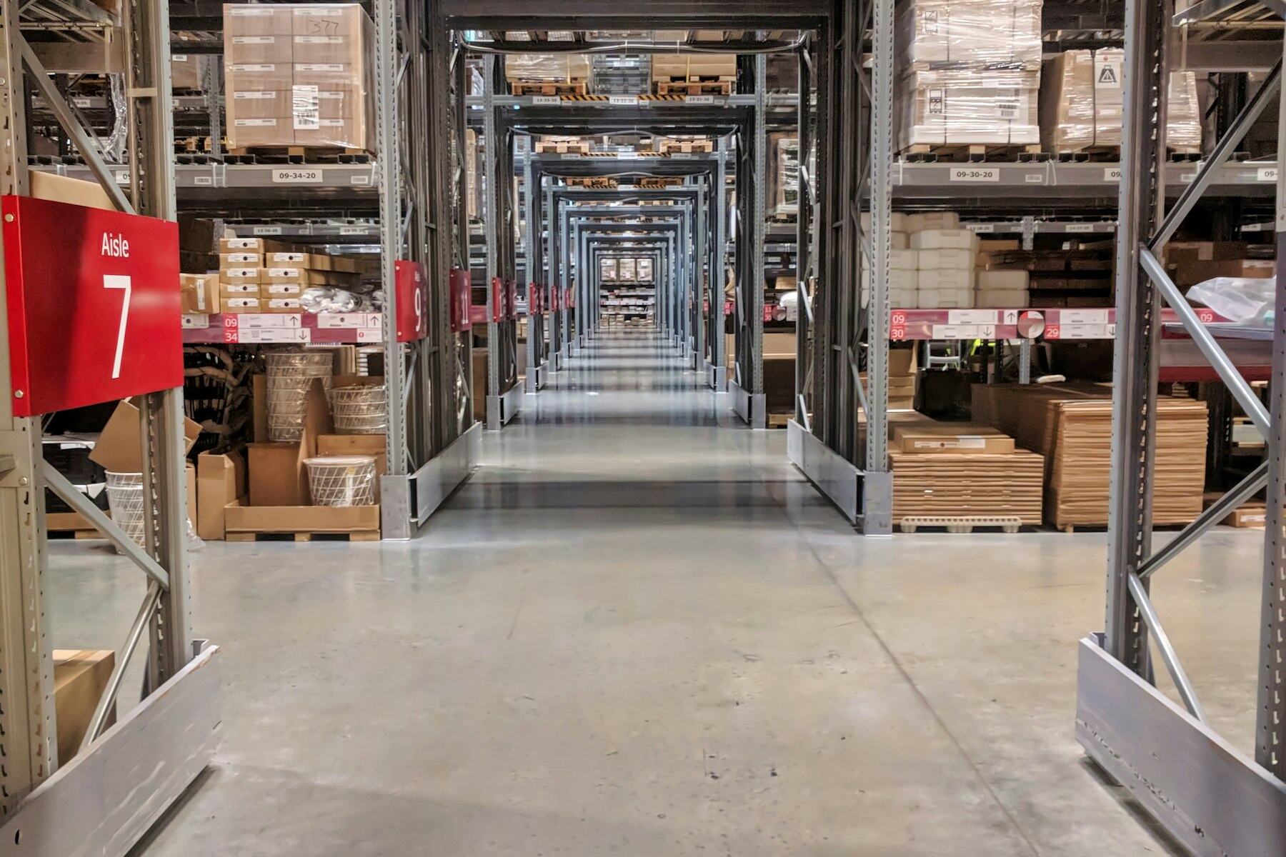 Aisle of a modern distribution centre stacked with cartons