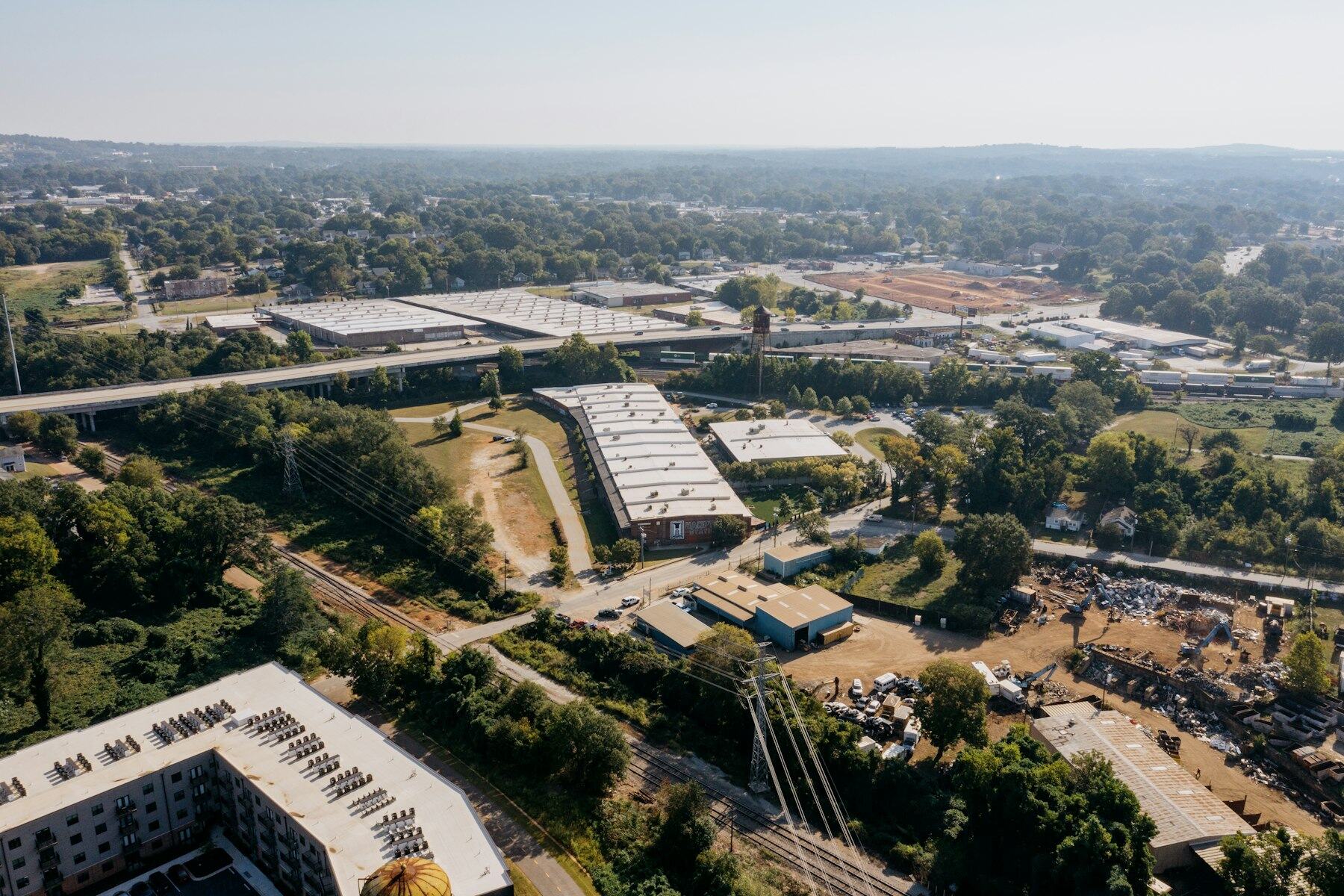 Aerial view of industrial buildings next to a highway overpass